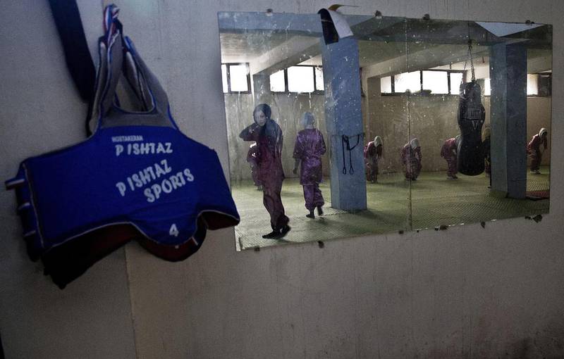 In this reflection, Shaolin martial arts students can be seen training at their club in Kabul on January 25, 2017. Massoud Hossaini / AP Photos