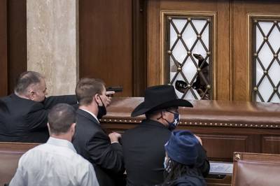 Security agents and members of Congress barricade the door to the House chamber as the violent mob breaches the Capitol. AP