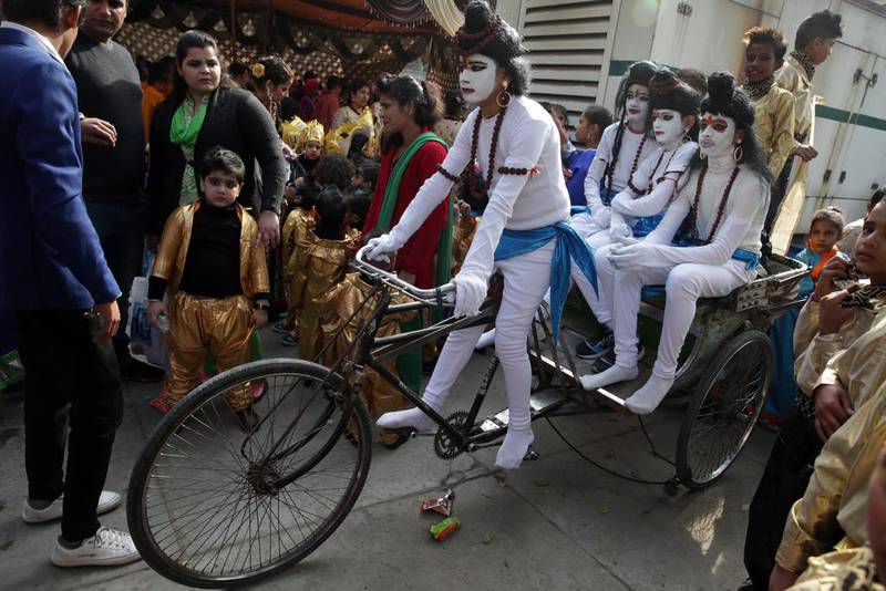 Schoolchildren, wearing religious make-up and attire, sit on a rickshaw on December 27, 2016, as they wait to perform in their school’s Annual Day function in Amritsar, India. Reminder Pal Singh / EPA