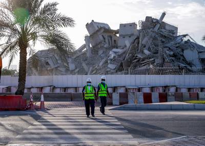 Abu Dhabi, United Arab Emirates, November 28, 2020.  The surrounding areas the morning after the demolition of the Mina Zayed Plaza. Workmen cross the street.Victor Besa/The NationalSection:  National News