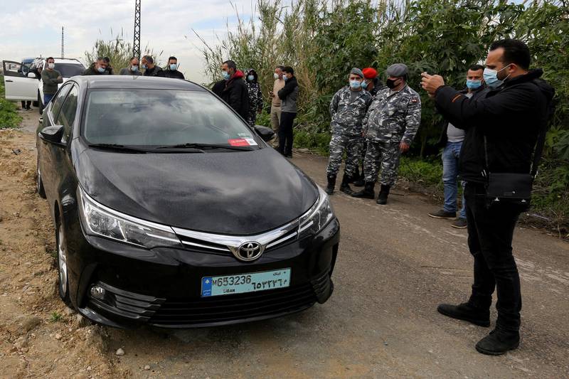 People gather near the car in which Lokman Slim, a prominent Lebanese Shiite critic of Lebanon's Iran-backed Hezbollah party and militia, was found killed. Reuters