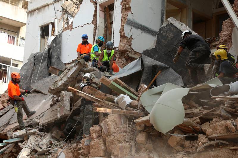 Rescue workers dig through the rubble of a badly damaged building in  Lebanon's capital Beirut in search of possible survivors from a mega-blast at the adjacent port one month ago. Reuters