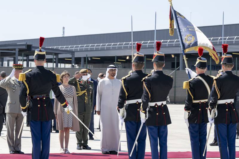 Sheikh Mohamed stands for the national anthem. Catherine Colonna, French Minister for Europe and Foreign Affairs, is also pictured. Photo: Presidential Court