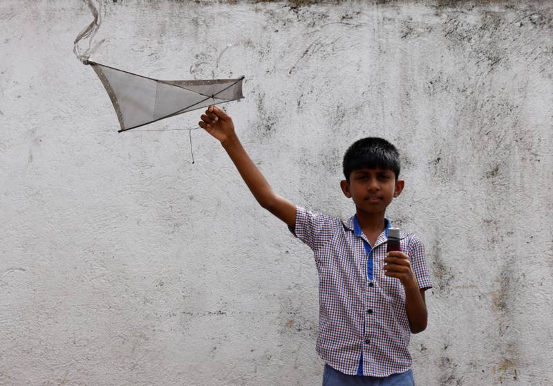 Oshada Fernando, 11, plays with a kite his uncle made for him. 'With the economic crisis we haven't bought any toys for our son,' said his mother, 42-year-old Anusha Priyadarshini.  