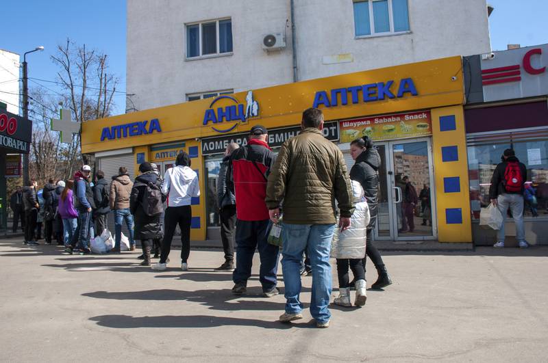 People queue at a pharmacy in Kharkiv. AP
