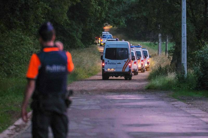 Police vehicles arrive to patrol the spot where the body of Jurgen Conings was found in Dilserbos. AFP