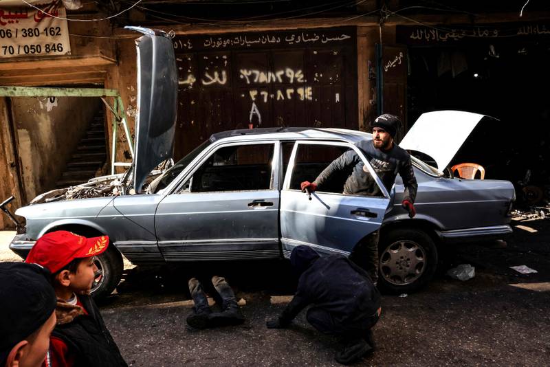 Mechanics repair a car in an alley in Bab al-Tabbane.
