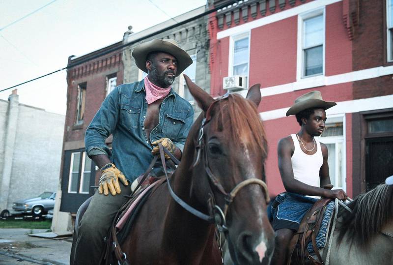 This image provided by Netflix shows Idris Elba, left, and Caleb McLaughlin in a scene from the film "Concrete Cowboy," premiering April 2 on Netflix. (Netflix via AP)