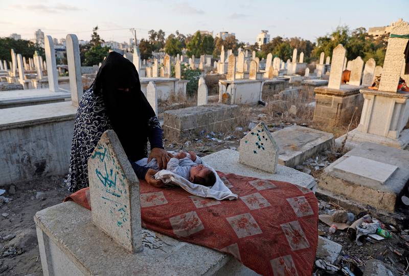 Kamilia Kuhail, 35, tends to her son Ahmed, in Sheikh Shaban cemetery. The pressure on space in the cemetery reflects the growing pressure on land in Gaza.