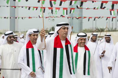 Jaber Al Suwaidi, general director of the Crown Prince Court - Abu Dhabi, dances during National Day celebrations. Seen with Ali Al Romaithi, executive director of business support division and Saif Al Qubaisi, executive director of the citizen affairs division. Ryan Carter / Crown Prince Court - Abu Dhabi