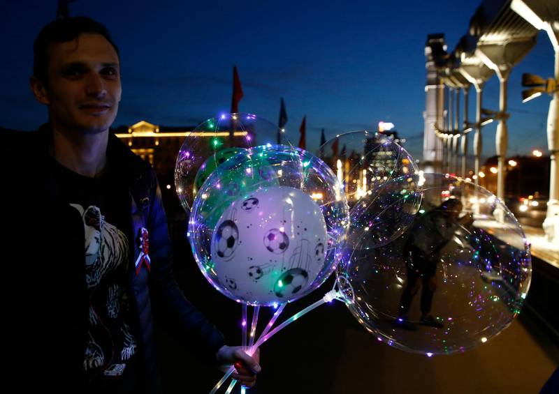A vendor sells balloons decorated with lights as a woman takes a photo, on a bridge in central Moscow during the 2018 World Cup. Rebecca Blackwell / AP Photo