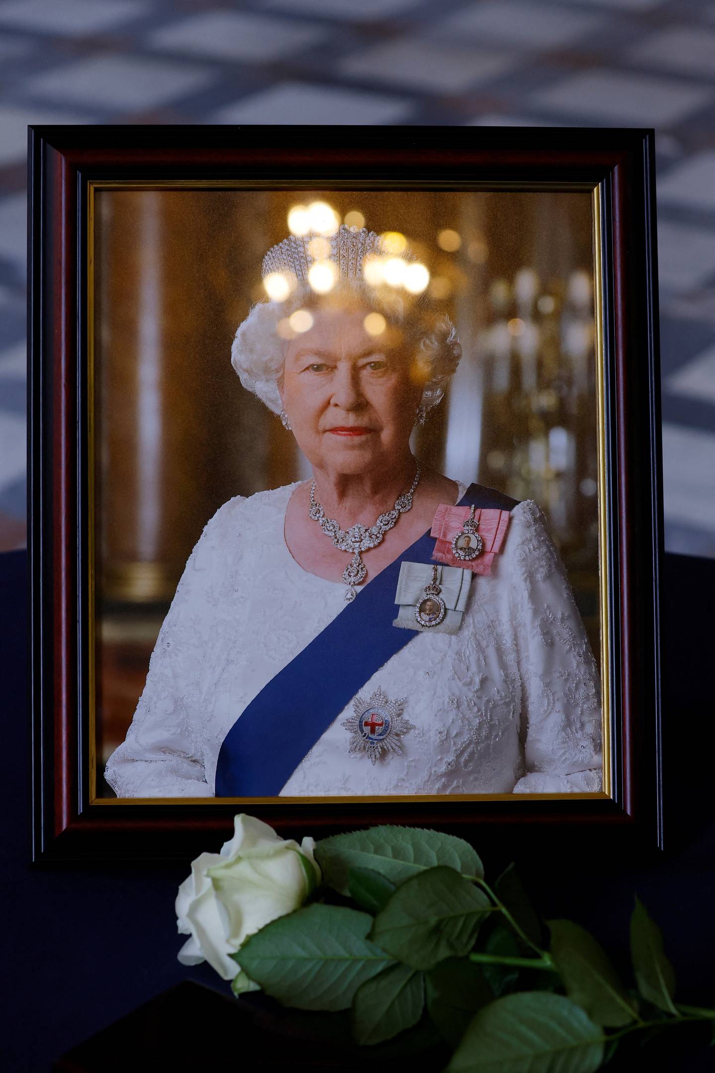 A white rose placed by French President Emmanuel Macron near a portrait of Queen Elizabeth at the British Embassy in Paris, France, on Friday.   