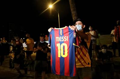 A Barcelona fan holds up a Lionel Messi shirt outside the Camp Nou. Reuters