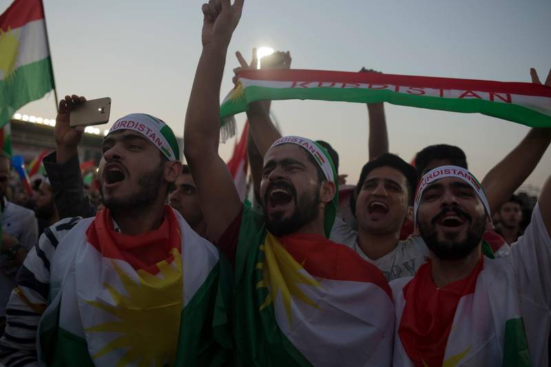 Pro independence supporters wrapped in Kurdish flags chant at a referendum rally in Irbil, Friday, Sept. 22, 2017. Speaking to the crowd of thousands in the Irbil soccer stadium Kurdish president, Masoud Barzani said the fight against the Islamic State group in partnership with the Iraqi military will "continue" despite the vote. (AP Photo/Bram Janssen)