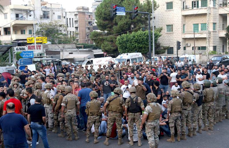 Lebanese security forces stand guard during a protest against dire economic conditions in the Lebanese southern port city of Sidon (Saida), on October 18, 2019. - Public anger has simmered since parliament passed an austerity budget in July to help trim a ballooning deficit and flared on Thursday over new plans to tax calls on messaging applications such as Whatsapp, forcing the government to axe the unpopular proposal. (Photo by AFP)