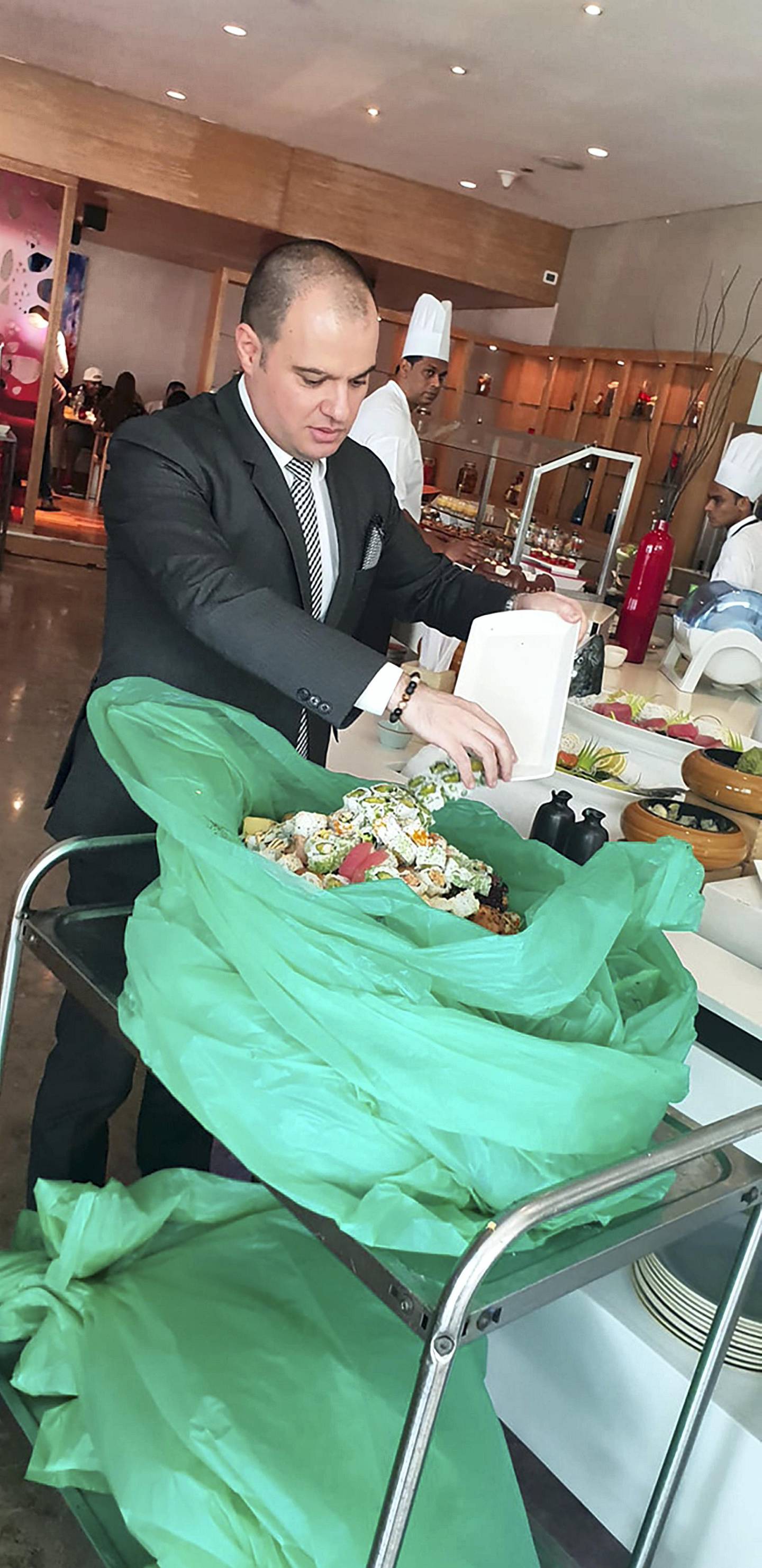An employee at Fairmont Bab Al Bahr hotel in Abu Dhabi prepares the leftover food from last Friday's brunch. Courtesy Jamal Al Breiki