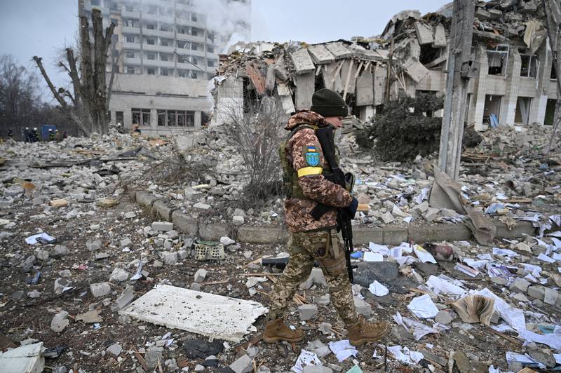 A Ukrainian service member walks near a school building destroyed by shelling in Zhytomyr, Ukraine. Reuters