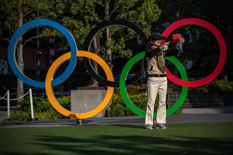TOKYO, JAPAN - APRIL 21: A woman takes a selfie in front of the Olympic Rings on April 21, 2021 in Tokyo, Japan. The Japanese government is expected to impose a third state of emergency in Tokyo soon amid an increase in cases of Covid-19 coronavirus in what experts have said is the fourth wave of the virus to hit the country. Prime Minister Yoshihide Suga has stated that any declaration would not affect the hosting of the Olympics which are now only three months away. (Photo by Carl Court/Getty Images)