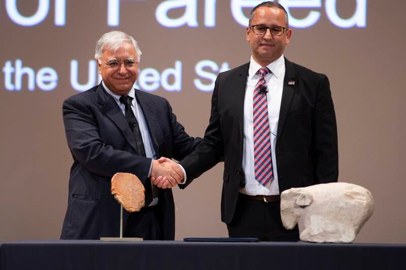 Iraqi ambassador to the US Fareed Yasseen shakes hands with Steven Francis, executive associate director of US Homeland Security Investigations, in front of the Gilgamesh tablet and a Sumerian ram statue at the repatriation ceremony in Washington, DC, on Thursday. EPA