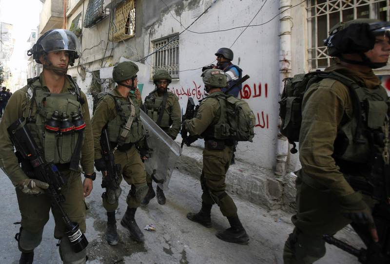 Israeli troops walk through the alleys of the refugee camp of Al Arrub, north of Hebron, in the occupied southern West Bank. The Israeli forces sent a patrol to the camp following calls for a demonstration in support of Gaza. AFP