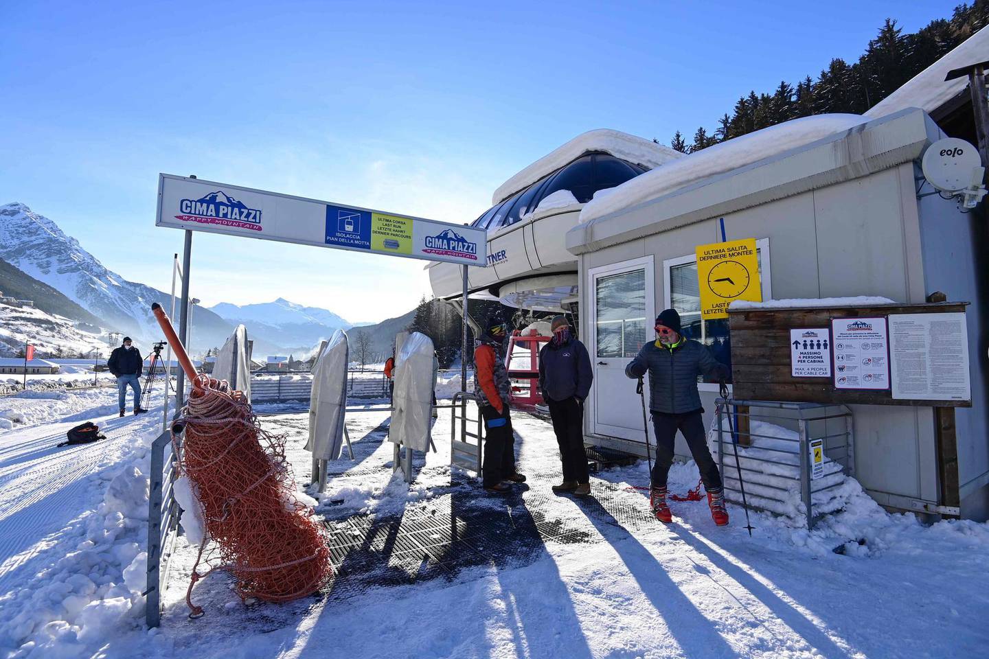 A skier (R) leaves the ski lifts of the Cima Piazzi ski resort in Isolaccia near Bormio, Italian Alps, on February 15, 2021. Italy's Health Ministry on February 14 decided to keep closed ski resorts that were due to reopen on February 15, due the progression of the coronavirus variants, until March 5, 2021, the expiry date of the government's latest decree. / AFP / MIGUEL MEDINA
