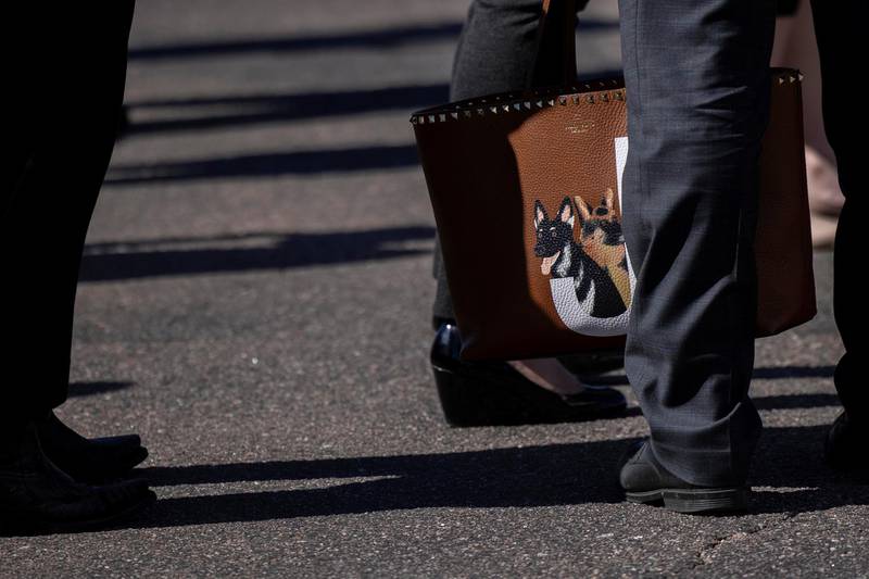 A member of staff holds Jill Biden's personal bag with a picture of the presidential pets, German Shepherds named Champ and Major, as she prepares to board a plane in Colorado Springs, Colorado, on May 6, 2021. Reuters