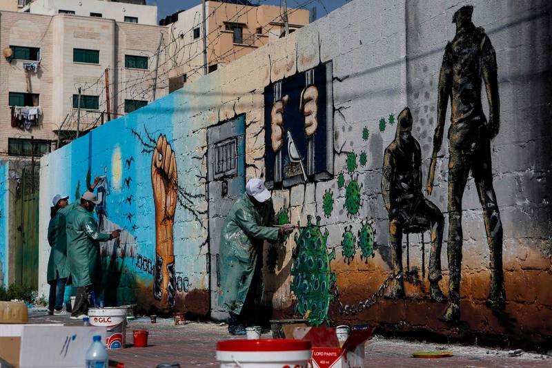 Palestinian artists paint a mural in a show of support for Palestinian prisoners held in Israeli jails amid the coronavirus pandemic, in Gaza City. AFP