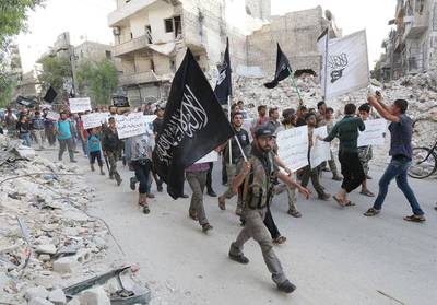 Supporters of Jabhat Al Nusra - Al Qaeda's Syria affiliate - hold placards denouncing President Bashar Al Assad and Arab states that have joined anti-ISIL campaign, as they demonstrate in the northern city of Alepppo on September 24, 2014. Zein Al Rifai/AFP Photo

