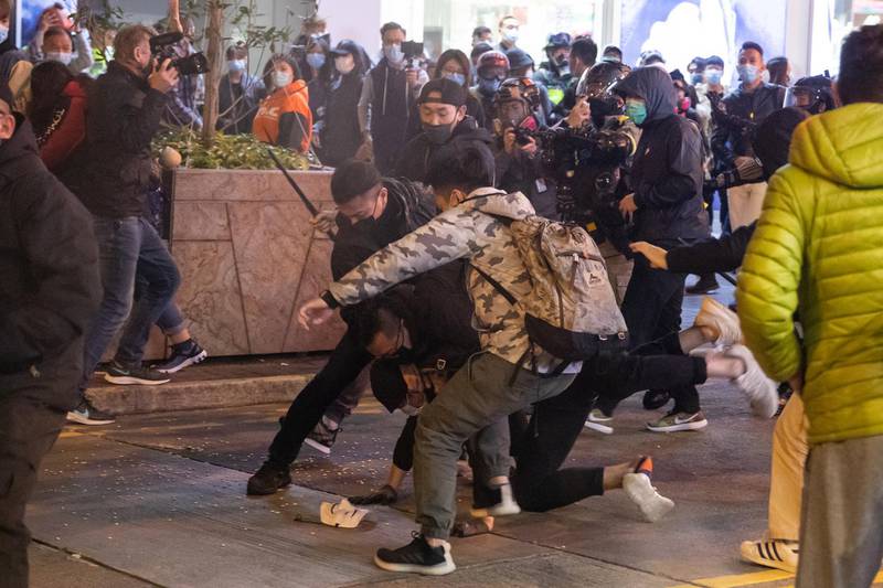 Men believed to be police officers dressed as protesters detain a demonstrator at a Lunar New Year temporary night market on Portland Street during a protest in the Mong Kok district of Hong Kong, China. Bloomberg