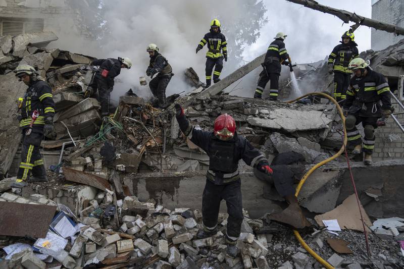 Rescue workers clearing rubble from a destroyed school after an attack in Kharkiv, Ukraine.  AP