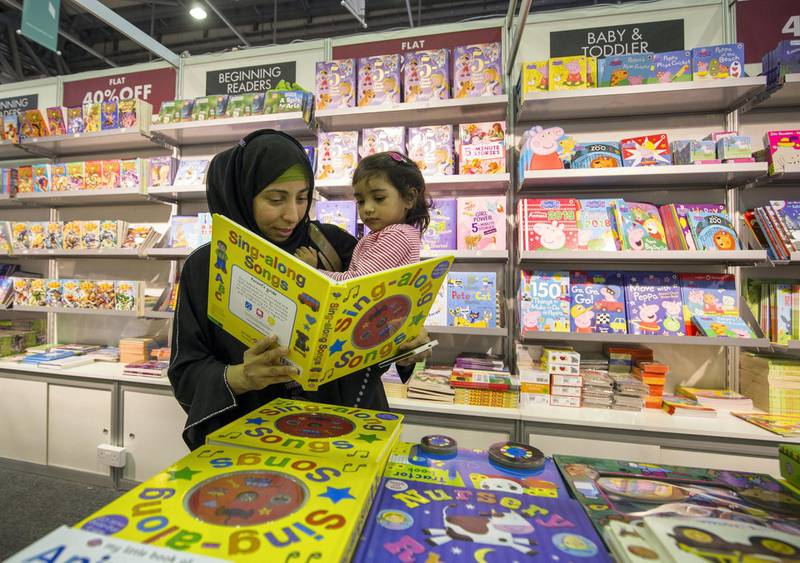 SHARJAH, UNITED ARAB EMIRATES - A mother singing a song to her daughter at The Sharjah Book Fair.  Leslie Pableo for The National