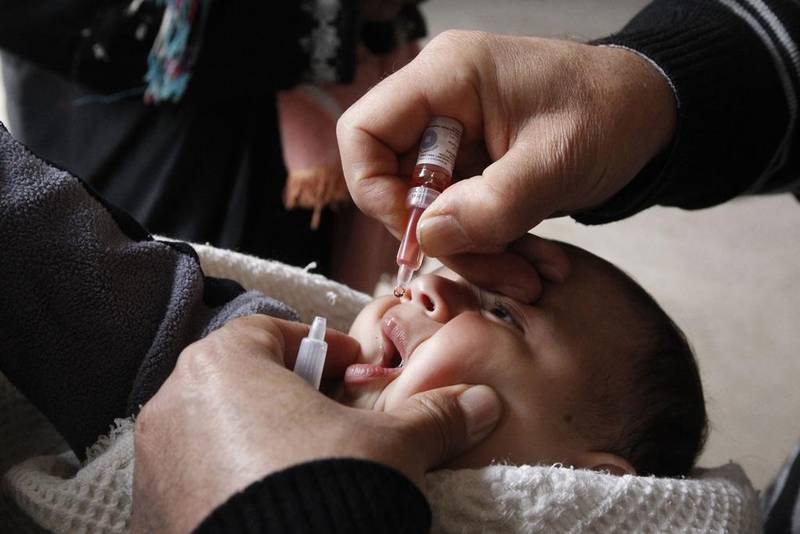 A health worker administers a polio vaccination to a child in Raqqa, eastern Syria. Public health researchers say missing vaccinations contributed to the re-emergence of polio in the area. Nour Fourat / Reuters