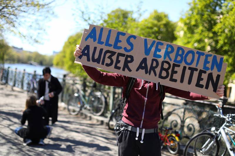 GERMANY: People hold a banner reading: "Everything prohibited except working" as they protest for the evacuation of refugees from camps in Greece, as the spread of coronavirus continues in Berlin, on April 19, 2020. Reuters