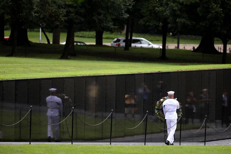 A US Navy seaman carries a wreath into the Vietnam Veterans Memorial before a ceremony to honour Mr McCain. Getty Images/AFP