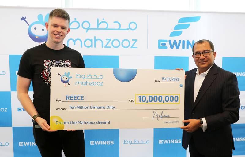 Reece (left) is presented with his Dh10 million cheque by Farid Samji, chief executive of Ewings, the operator of Mahzooz. 