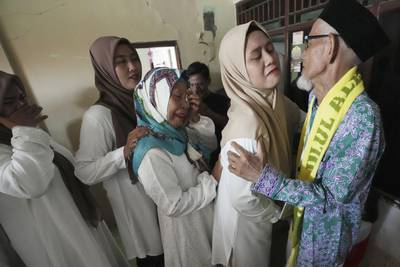 Husin bin Nisan, right, bids farewell to relatives before departure for the Hajj pilgrimage at his house in Tangerang, Indonesia. AP Photo