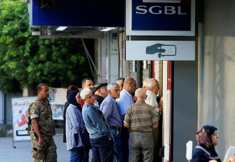 People queue outside a branch of SGBL bank in Sidon, Lebanon November 1, 2019. REUTERS/Ali Hashisho