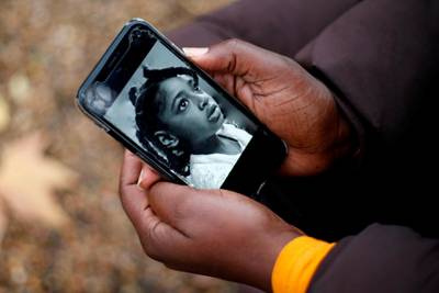 (FILES) In this file photo taken on November 30, 2020 Rosamund Adoo-Kissi-Debrah holds her mobile phone displaying a photograph of her daughter Ella Adoo-Kissi-Debrah who died died in February 2013 from a severe asthma attack ahead of the opening of a coroner's inquest into the girl's death in London.  The mother of a girl who died of an asthma attack in London seven years ago explained in court on Monday, December 7, that she would have moved if she had experienced the impact of air pollution.
 / AFP / Hollie Adams
