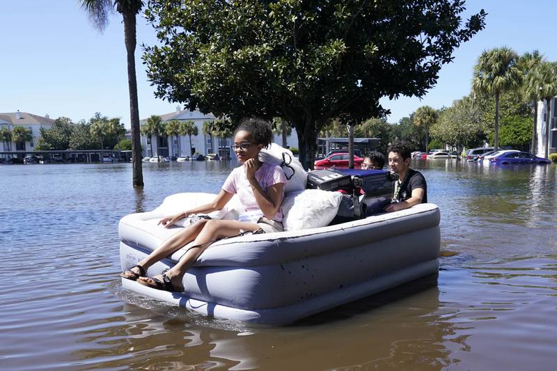 University of Central Florida students use an inflatable mattress as they leave an apartment complex near campus that was flooded during the hurricane in Orlando, Florida. AP