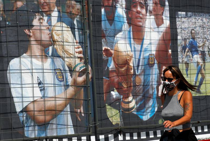 A woman walks past a billboard in homage to Maradona on his 60th birthday, near the Buenos Aires' Obelisk. Reuters