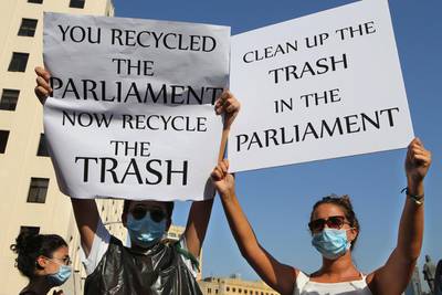Lebanese protesters hold up placards as they protest against the trash crisis. Hussein Malla / AP Photo