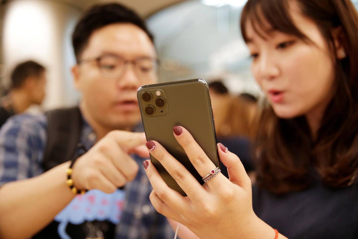 Customers check a new iPhone at the Apple Store in Beijing. Reuters