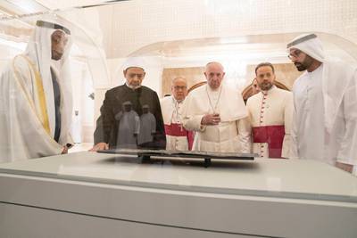 ABU DHABI, UNITED ARAB EMIRATES - February 4, 2019: Day two of the UAE papal visit -  HH Sheikh Mohamed bin Zayed Al Nahyan, Crown Prince of Abu Dhabi and Deputy Supreme Commander of the UAE Armed Forces (L), His Eminence Dr Ahmad Al Tayyeb, Grand Imam of the Al Azhar Al Sharif (centre L), His Holiness Pope Francis, Head of the Catholic Church (centre R), and HE Mohamed Khalifa Al Mubarak, Chairman of the Department of Culture and Tourism and Abu Dhabi Executive Council Member (R), look at leaves from the Blue Qurían courtesy of Zayed National Museum, during a dinner reception at Al Mushrif Palace. 
( Ryan Carter / Ministry of Presidential Affairs )
---