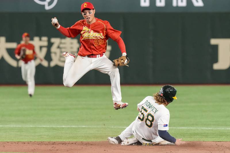 China's Luo Jinjun catches the ball as Australia's Jake Bowey slides into second base during their Pool B game, at the World Baseball Classic, in Tokyo, Japan. AP