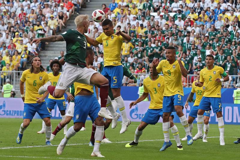 Brazil's Casemiro, top right, heads the ball away next to Mexico's Carlos Salcedo, top left. Thanassis Stavrakis / AP Photo