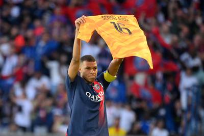 PSG forward Kylian Mbappe holds up a jersey of teammate Sergio Rico who is in serious condition after a horse-riding accident. AFP