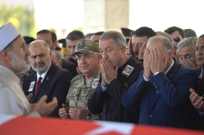 Turkish Defense Minister Hulusi Akar (C) and relatives of Turkish soldier Ahmet Topcu who was killed during the military operation in Kurdish areas, pray near by his coffin during a military funeral in Ankara, Turkey. Turkey has launched an offensive targeting Kurdish forces in north-eastern Syria, days after the US withdrew troops from the area.  EPA