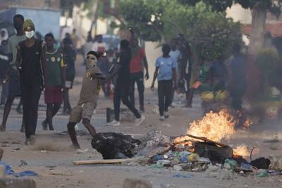 A demonstrator throws a rock at police during a protest in the neighbourhood of Dakar. AP