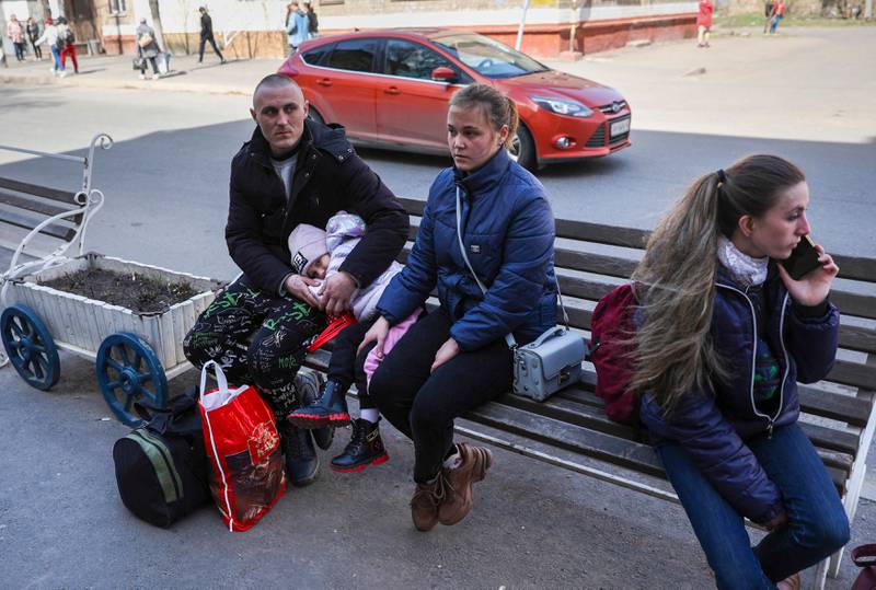 Survivors of the attack sit on a bench outside the station. AFP