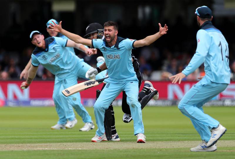 England's Mark Wood, center, celebrates the dismissal of New Zealand's Ross Taylor, partially seen behind Wood, during the Cricket World Cup final match between England and New Zealand at Lord's cricket ground in London, England, Sunday, July 14, 2019. (AP Photo/Aijaz Rahi)